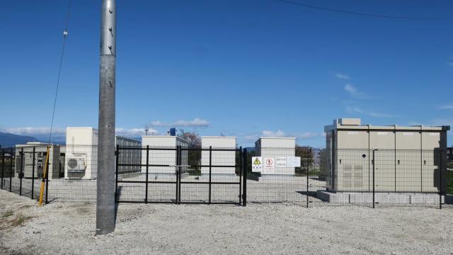 File di container bianchi di un impianto di accumulo elettrochimico collegati alla rete elettrica