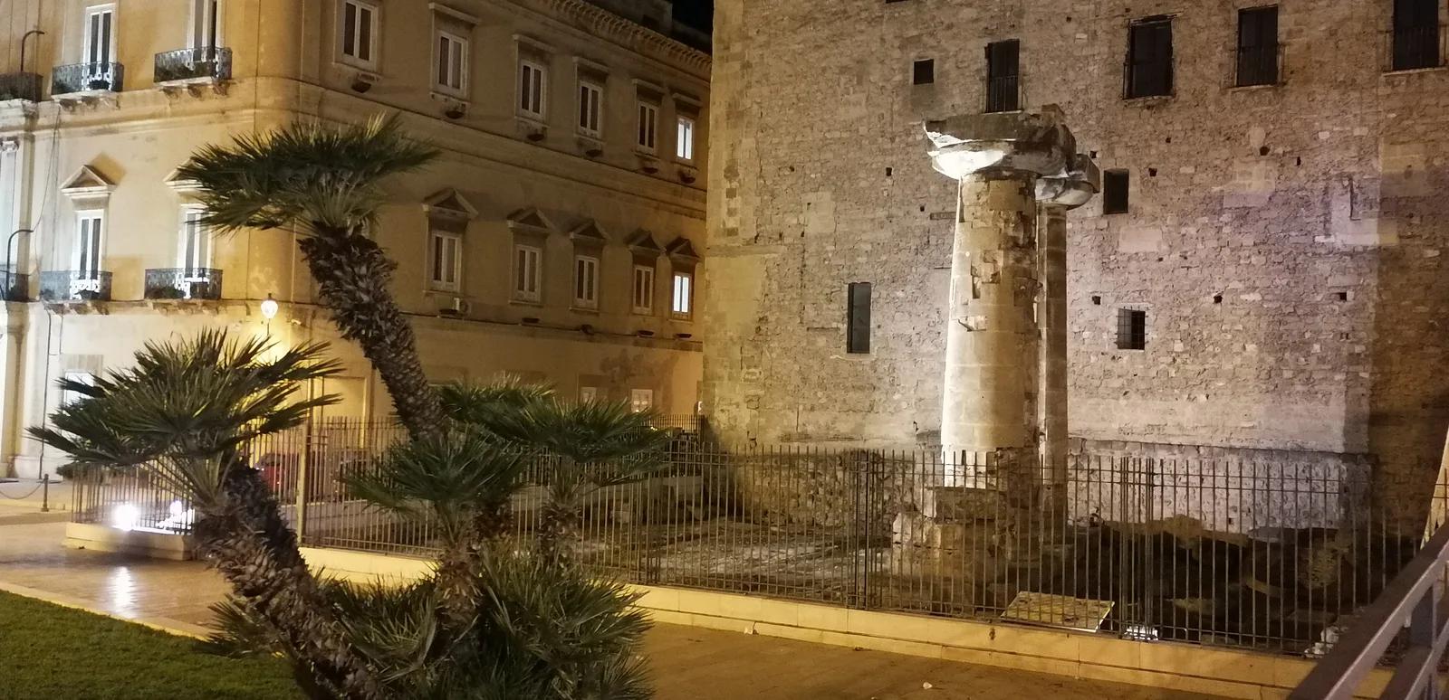 Piazza Castello a Taranto di notte, con le colonne doriche del tempio illuminate