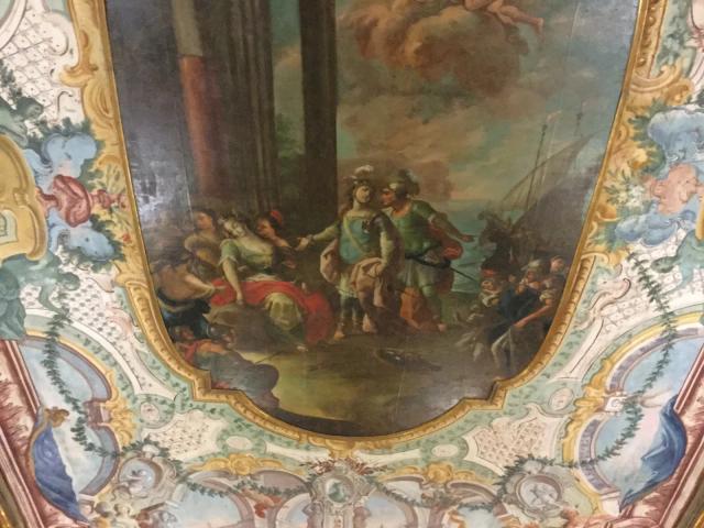 Un soffitto dipinto di Palazzo Pantaleo con la scena di Enea che abbandona Didone, in una cornice di stucchi colorati