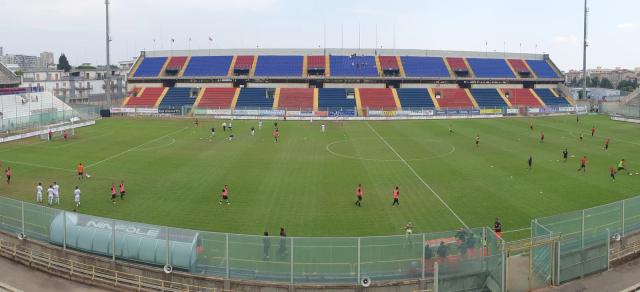 Lo stadio Iacovone di Taranto visto dalle tribune, con il prato verde e i seggiolini rossi e blu della tribuna di fronte